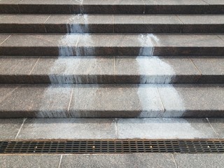 spilled white liquid mess on stairs or steps with metal drain