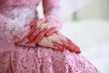 Bride hand with beautiful henna design and rind