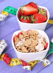 Fresh strawberries, wheat and rye flakes and centimeter, slimming and healthy lifestyle concept