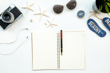 Flat lay of top view holiday journey cencept with retro film camera sunglasses and compass include space in a book for add text