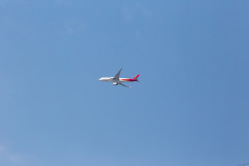 An airplane flying in the blue sky. passenger plane flies highly over clouds of aerosphere.  airplane flying in a clear pale blue sky. An airplane taking off at airport.