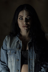 Scary woman with mad eyes in darkness