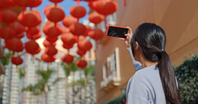 Woman take photo on cellphone for red lantern