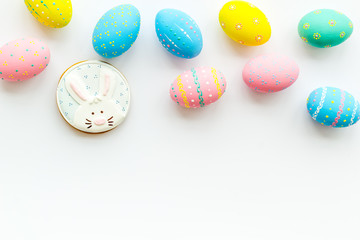 Easter symbols. Colorful Easter eggs and gingerbread on white background copy space