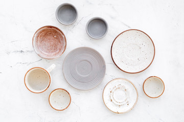 Kitchen concept. Crockery kit. Empty ceramic plates and mugs on white background top view
