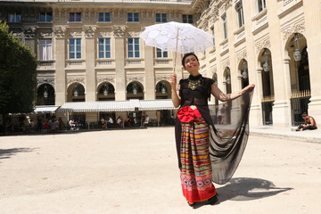 Femme dépliant sa robe dans la cour du palais royal à Paris