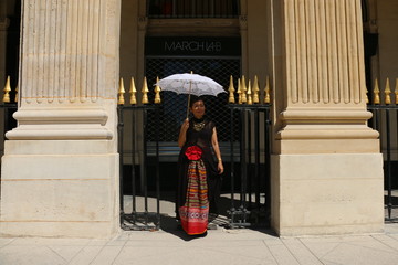 Fototapeta na wymiar Femme devant les grilles des arcades du palais royal à Paris