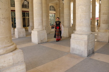 Femme au milieu des arcades du palais royal à Paris