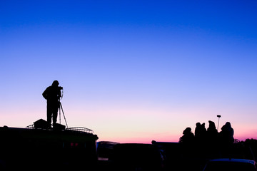 silhouette of photographer take photo in sunset time 