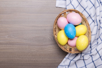 Easter eggs in the basket on wooden background