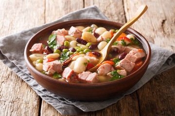 Recipe for soup from beans, peas, ham, tomatoes and herbs closeup in a bowl. horizontal