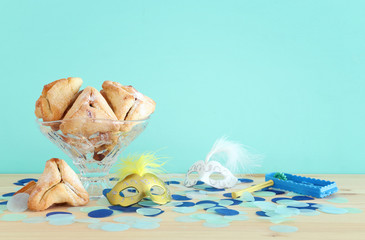 Purim celebration concept (jewish carnival holiday) over wooden table.