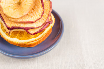 Healthy food organic nutrition. Sliced and dried apple, orange on textile background.