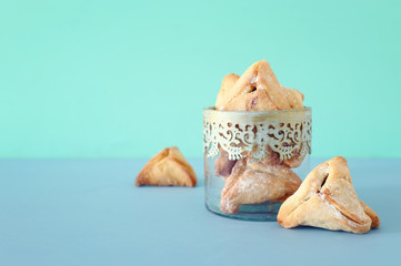 Purim celebration concept (jewish carnival holiday). Traditional hamantaschen cookies over wooden table