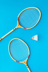 Badminton concept. Badminton rackets and shuttlecock on blue background top view pattern