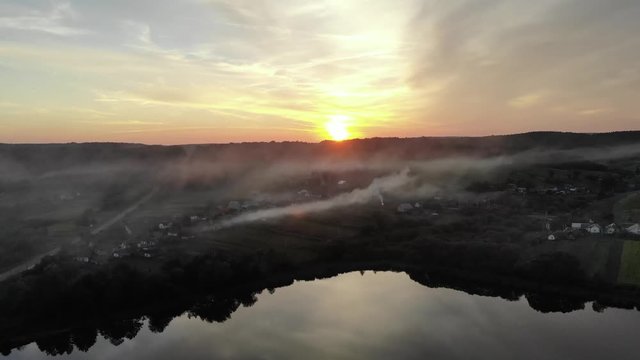 Aerial shot of smoke covering willage on autumn sunset. 4K