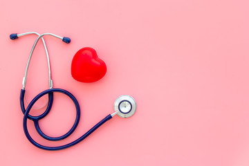 Heart health, health care concept. Stethoscope near rubber heart on pink background top view space...