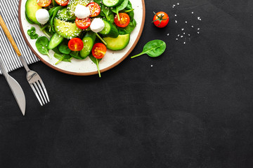Healthy lunch. Fresh vegetable salad on black background top view copy space