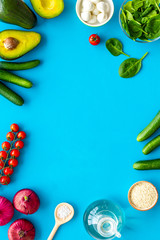 Fresh organic vegetables on blue background top view space for text. Kitchen desk for preparing salad frame