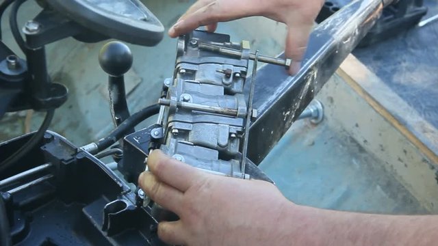 The repair of outboard motor for marine boat. Boat motor and man's hands close-up.