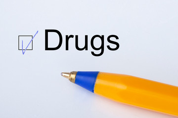 Drugs - checkbox with a tick on white paper with yellow pen. Checklist concept.