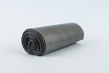 Black plastic polyethylene garbage bags roll isolated over the white background.
