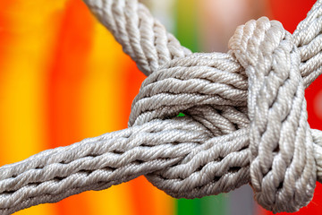 Close-up of rope knot line tied together with playground background
