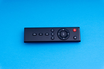 Remote control TV or radio isolated on blue background with selective focus and crop fragment