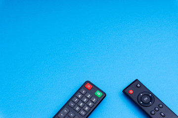 Remote control TV or radio isolated on blue background with selective focus and crop fragment