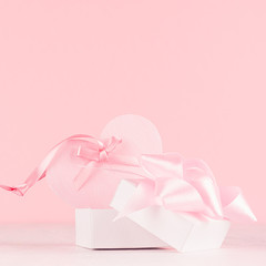 Girlish gentle Valentine days background - soft pastel pink heart with ribbon and bow on white wood board.
