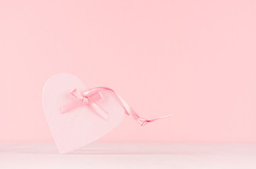 Valentine days background - elegant pastel pink decorative heart with ribbon on white wood board, copy space.