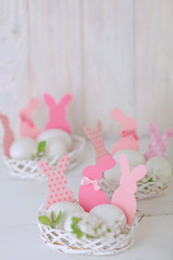 Happy easter. Decor of Easter eggs in the form of Easter bunnies in small white baskets.