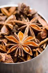 Dried anise stars in metal cup on the rustic background. Selective focus. Shallow depth of field.
