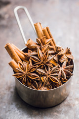 Dried anise stars in metal cup on the rustic background. Selective focus. Shallow depth of field.