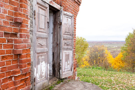A wooden double door in an old abandoned house. One door leaf is open. Rukavishnikov manor in the village of Podviazye, Bogorodsky District. - Powered by Adobe