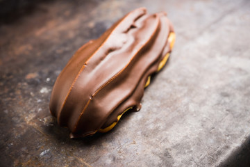 Fresh eclair with chocolate glaze. Selective focus. Shallow depth of field.