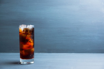 Cold cola beverage in glass with ice. Selective focus. Shallow depth of field.