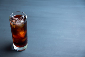 Cold cola beverage in glass with ice. Selective focus. Shallow depth of field.
