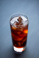 Cold cola beverage in glass with ice. Selective focus. Shallow depth of field.