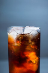 Cold cola beverage in glass with ice. Selective focus. Shallow depth of field.