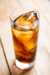 Cold cola beverage in glass with ice. Selective focus. Shallow depth of field.