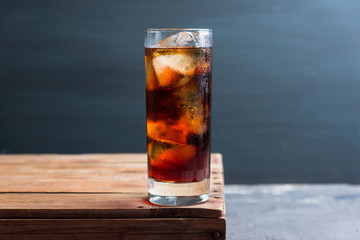 Cold cola beverage in glass with ice. Selective focus. Shallow depth of field.
