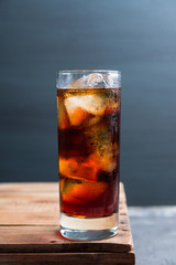 Cold cola beverage in glass with ice. Selective focus. Shallow depth of field.