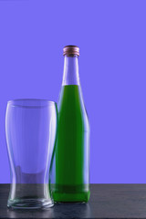 a bottle of refreshing lemonade and a glass with clear glass on a blue background