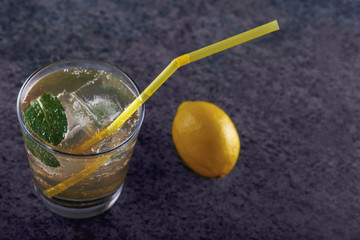 a glass of refreshing lemonade with mint and ice on a wooden table