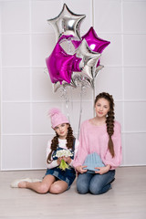 Beautiful girl friends in denim clothing. Fashion. Two girls models in jeans and sweaters.