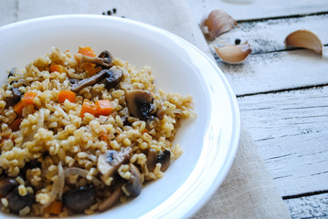Bulgur with vegetables in a white plate