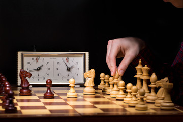 hand of businessman moving chess figure in competition success play. strategy, management or leadership concept
