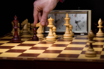 hand of businessman moving chess figure in competition success play. strategy, management or leadership concept