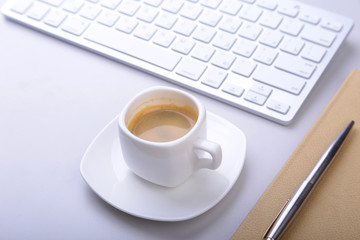 office table with notebook, computer keyboard,, cup of coffee, tablet pc. copy space.
